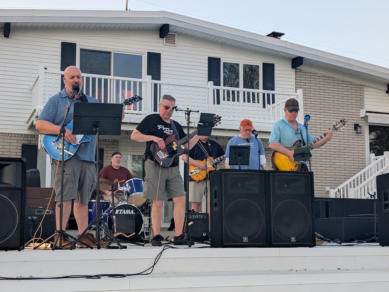 Special Blend performing outdoors on a sunny deck stage with electric guitars, bass, and drums