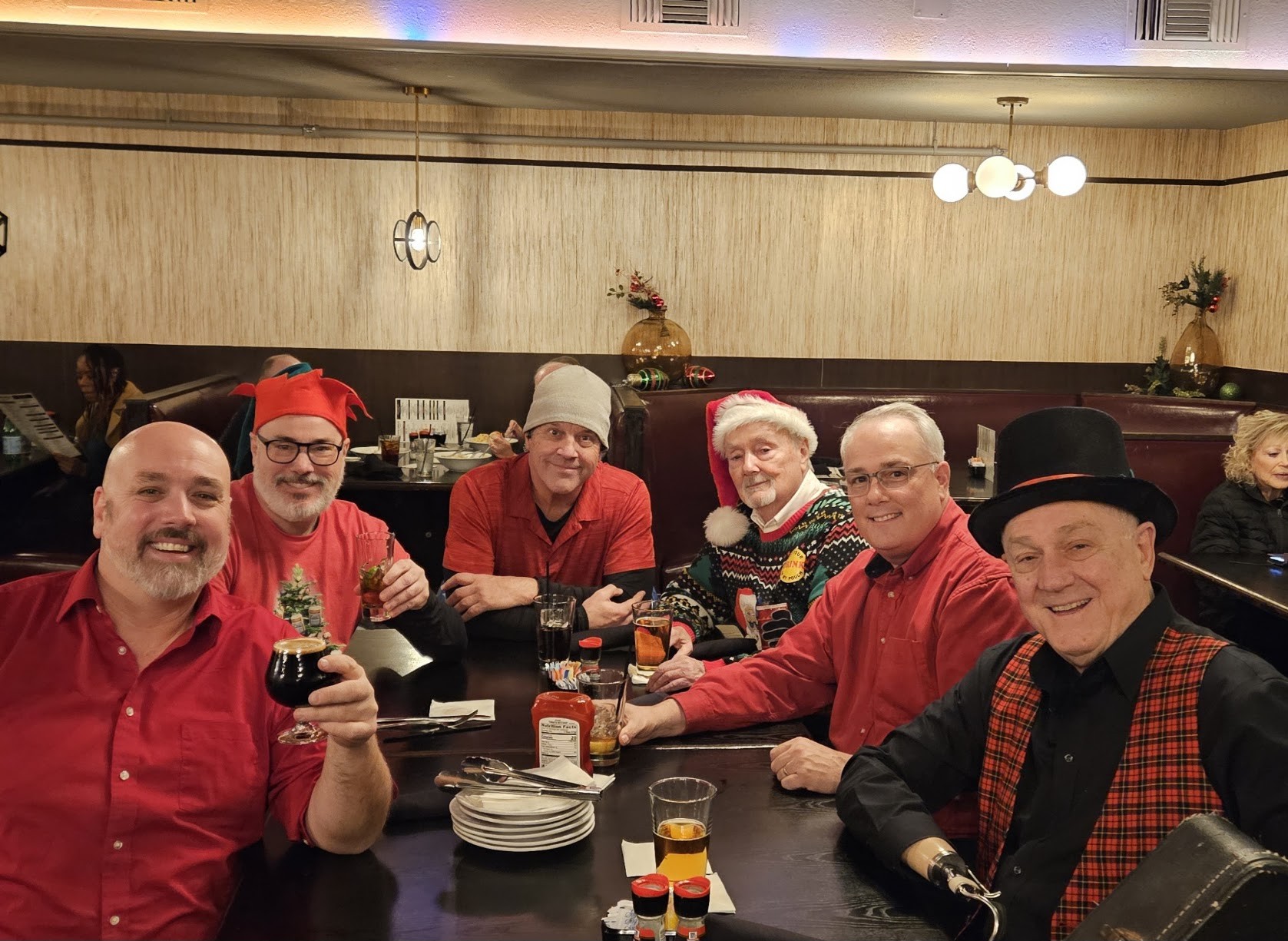 Special Blend band members smiling and raising a glass together at a holiday dinner table