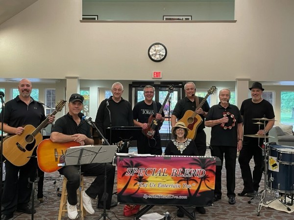 Special Blend full band smiling behind the Special Blend sunset palm banner